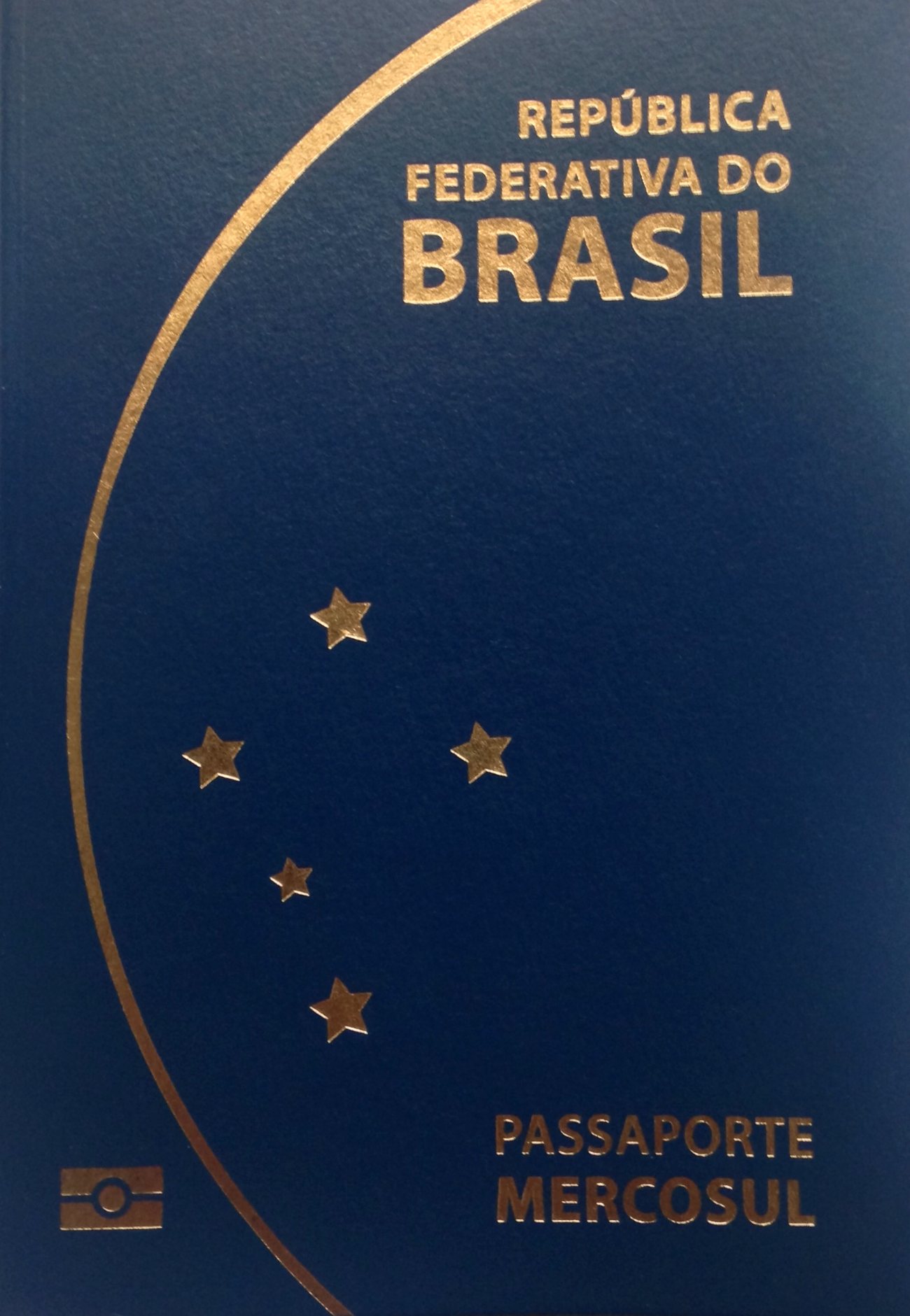 A Brazilian passport and official residency documents on a table