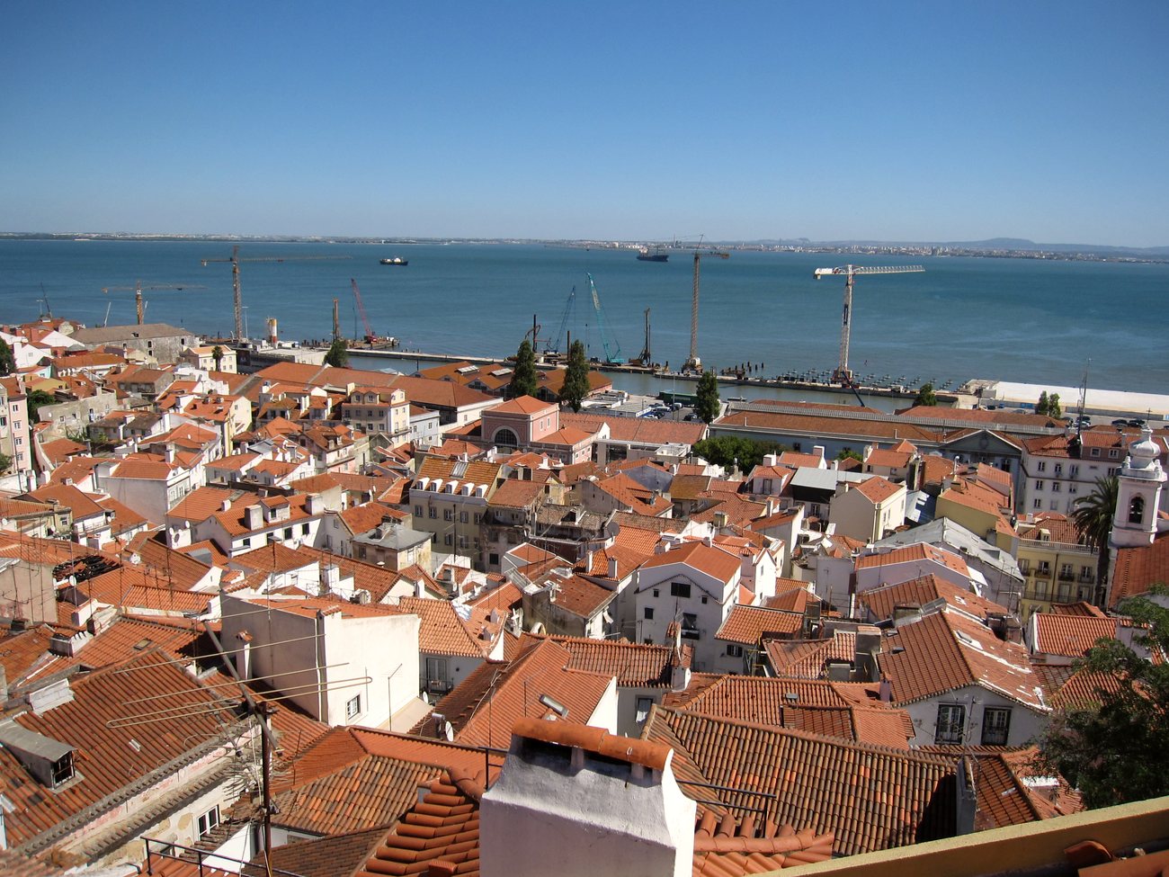 Terracotta rooftops and a yellow tram in the Alfama district of Lisbon