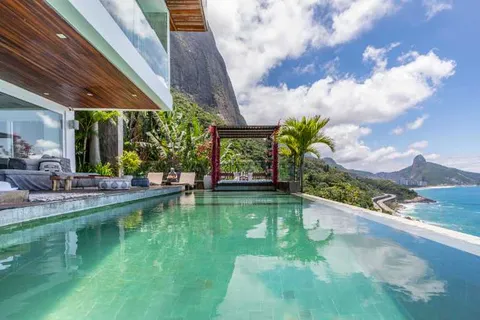 Three-level villa with five suites and an infinity pool above the sea in Joá